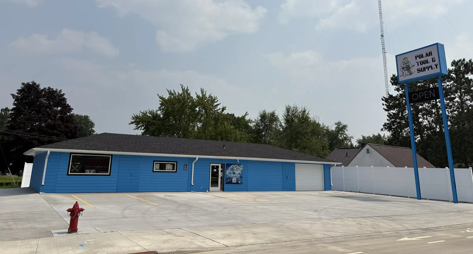 Blue building with a red fire hydrant in front on a clear day